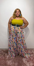 Load image into Gallery viewer, Woman in a yellow top and floral palazzo pant standing in front of a decorative floral arch.