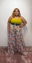 Load image into Gallery viewer, Woman in a yellow top and floral palazzo pant standing in front of a decorative floral arch.
